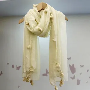 Nahaufnahme des eleganten beige Baumwoll Leinen Schals mit zarten dekorativen Quasten im Detail.
