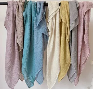 Close-up detail of multi-colored crinkled textured cotton linen scarves hanging on a rod.