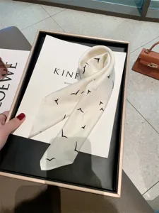 Chic minimalist ivory narrow silk scarf featuring a stylish black flying birds print detail.