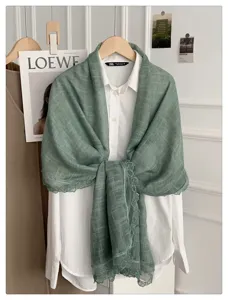 Gedetailleerd overzicht van elegante groene katoen linnen kant sjaal, lente herfst accessoire.