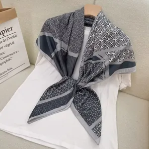 Nahaufnahme des eleganten quadratischen Schals mit geometrischem Kettenmuster auf weißem Shirt.