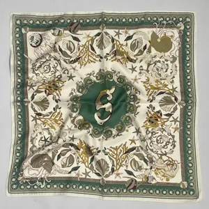 Elegante pañuelo de seda cuadrado con un estampado marino de conchas y monograma.
