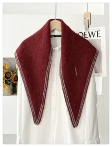Detalle de cerca del elegante chal pañuelo triangular de punto rojo oscuro con rayas.