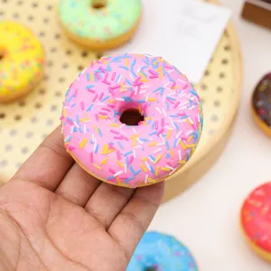 Macro detail shot of a pink PU simulated donut fridge magnet with colorful sprinkles.