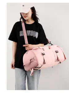 Große rosa Reisetasche mit praktischem Schuhfach, von einem Model beim Reisen getragen
