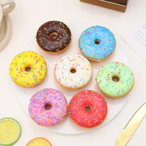Detailed view of seven colorful artificial PU donuts with rainbow sprinkles on a white plate