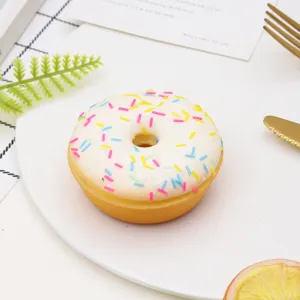 Realistic PU donut prop with white frosting and colorful sprinkles on a white plate