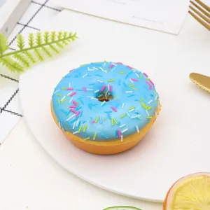 Detailed view of artificial blue donut with colorful sprinkles for photography props.