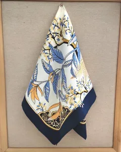 Seidentuch Detail mit filigranem blau-gelben Blumenmuster und elegantem dunkelblauen Schmuckrand.