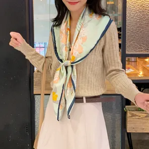 Dettaglio di un foulard quadrato in seta stampata con eleganti e raffinati motivi floreali.