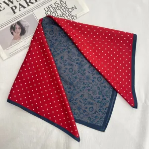 Vista detallada de un pañuelo de seda elegante con estampado de estrellas rojas y flores.
