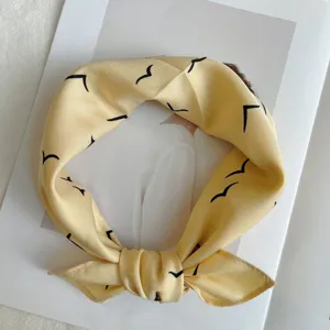 Yellow silk square scarf with chic bird print, versatile thin head wrap for women.