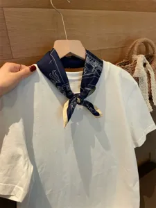 Detailansicht des eleganten dunkelblauen Seiden-Quadratschals mit weißen Linienmotiven.