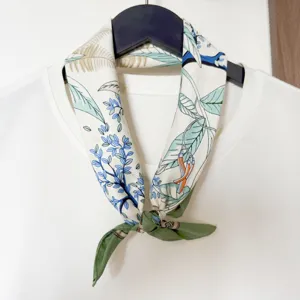 Nahaufnahme Detail eines botanischen Blumenmuster Seidenquadrattuchs an einem weißen Hemd.