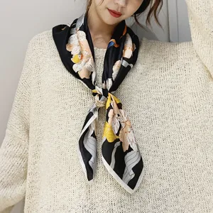 Vista dettagliata di un foulard quadrato in seta nera con stampa floreale e animale donna.