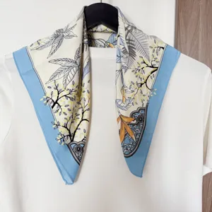 Seiden-Quadrat-Schal mit eleganten Blumenmotiven und kontrastierenden blauen Rändern für Damen.