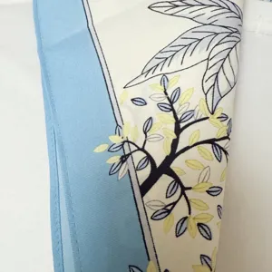 Nahaufnahme Detail eines Kunstseiden-Quadrat-Schals mit Blumenmuster und blauem Rand.