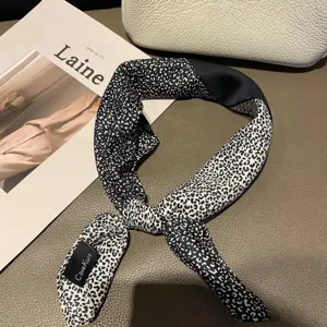 Détail de foulard en soie à imprimé léopard noir et blanc, élégant petit carré en twill.