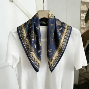 Vista detallada del pañuelo de seda azul oscuro con elegante estampado celestial dorado.