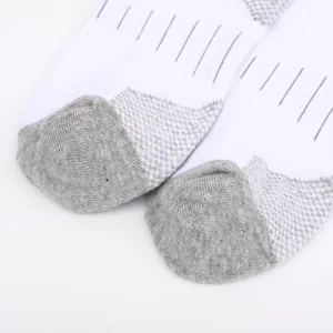 Nahaufnahme von weißen Sportsocken mit atmungsaktiver Mesh Textur und grauen Zehen.