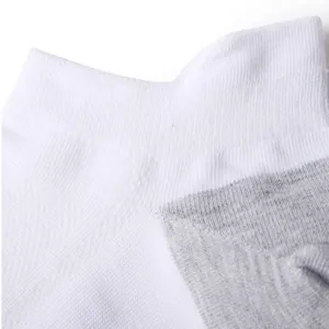 Close-up detail of white and grey low-cut sports ankle socks, soft and breathable fabric.