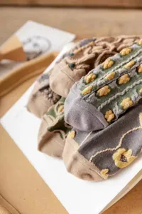 Close-up detail shot of vintage floral embossed women socks showing fine knitted texture.