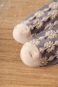 Close-up detail of retro floral embroidered short socks with comfortable toe design on wood.