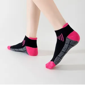 Close-up detail of breathable athletic running socks with pink and black mesh pattern.