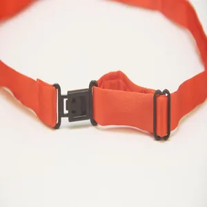 Dettaglio cinturino in nastro arancione regolabile per fiocco JK, con fibbia in plastica.