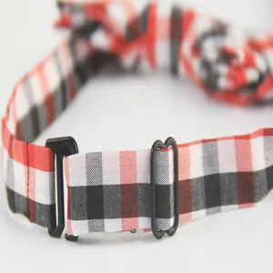 Close-up detail of the adjustable strap and plastic buckle on a red plaid kids bow tie.