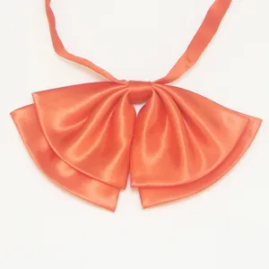 Primo piano del fiocco uniforme JK in raso arancione, dettagli in tessuto di nastro liscio.