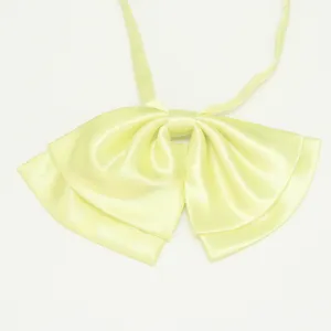 Dettaglio del fiocco in raso giallo chiaro, accessorio per uniforme JK in dolce stile scolastico.