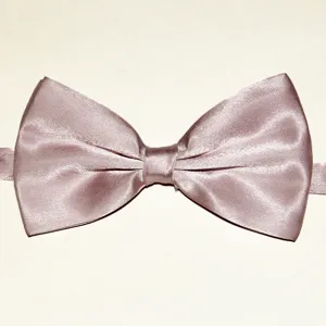 Vue de détail rapprochée d'un nœud papillon rose clair en tissu polyester satiné.