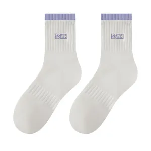 White mid-tube cotton socks for women with purple ribbed cuffs and stylish embroidered details.