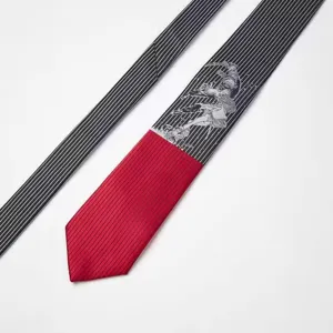 Close-up detail of the designer black and red striped tie featuring unique graphic print.