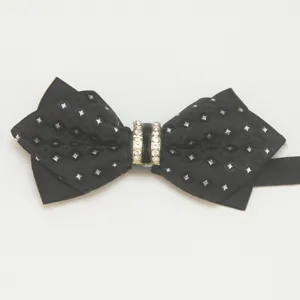 Detailed shot of men's black pointed bow tie featuring diamond pattern fabric and rhinestone center.