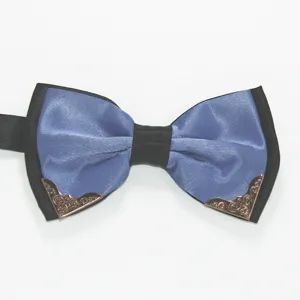 Close-up detail of the stylish blue and black men's bow tie featuring ornate metallic corners.
