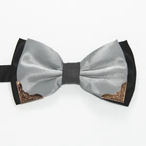 Detail view of a black and silver double layer bow tie featuring stylish bronze metal corner accents.