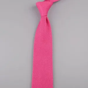 Primo piano di una cravatta lavorata a maglia rosa vivo da uomo con trama fine e punta.