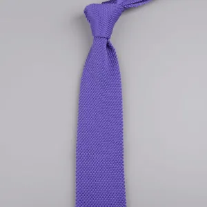 Primo piano di una elegante cravatta in maglia viola con trama fine e design appuntito.