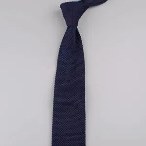 Vista dettagliata di una cravatta lavorata a maglia blu scuro da uomo con finitura strutturata.