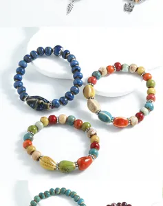 Close-up of colorful ceramic beaded bracelets featuring ethnic style and vintage metal charms.