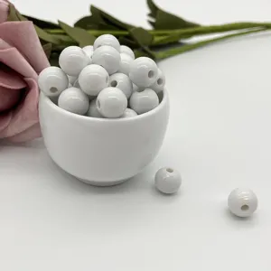 Closeup of white ceramic loose beads with drilled holes, perfect for DIY jewelry making and crafts.