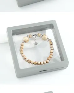 Detail view of the Chinese style ceramic beaded bracelet with metal spacers and star pendant.