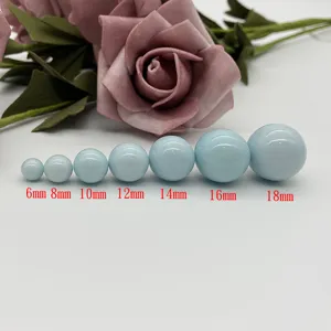 Detail view of light blue ceramic beads in multiple sizes from 6mm to 18mm for DIY jewelry.