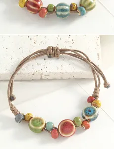 Exquisite handmade ceramic beaded bracelet detail showcasing multi-colored glazed beads and cord.