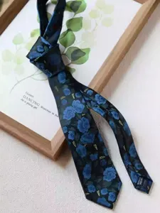 Close-up view of the dark blue floral necktie featuring exquisite vintage botanical print.