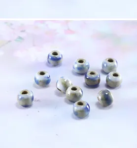 Detalle de cuentas de ceramica hechas a mano, accesorio de joyeria DIY de porcelana azul.
