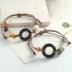 Retro handmade ceramic bead bracelet with woven cord and black ring pendant for women.