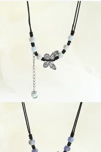 Exquisite ceramic butterfly necklace detail showing delicate beads and metal pendant craftsmanship.